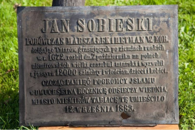 Współczesne zdjęcie. Przedstawia tablicę umieszczoną na pomniku Jana III Sobieskiego w Niemirowie. Na niej napis: JAN SOBIESKI / PODÓWCZAS MARSZAŁEK I HETMAN W. KOR. / ścigając Tatarów, grasujących po ziemiach ruskich / w r. 1672, rozbił dn. 7. października na polach / niemirowskich wielki czambuł tatarski i wyzwolił / z jassyru 12 000 szlachty i włościan, dzieci i kobiet. / CZCZĄC PAMIĘĆ POGROMCY ISLAMU / w DWUCHSETNĄ ROCZNICĘ ODSIECZY WIEDNIA / MIASTO NIEMIRÓW TABLICĘ TĘ UMIEŚCIŁO / 12. WRZESNIA 1883.