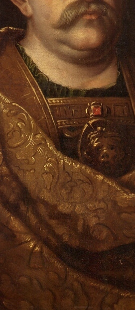 Zbliżenie na fragment obrazu olejnego "Jan III Sobieski w wieńcu laurowym". Połyskująca złotem szata. Na wysokości piersi króla wizerunek Gorogony.