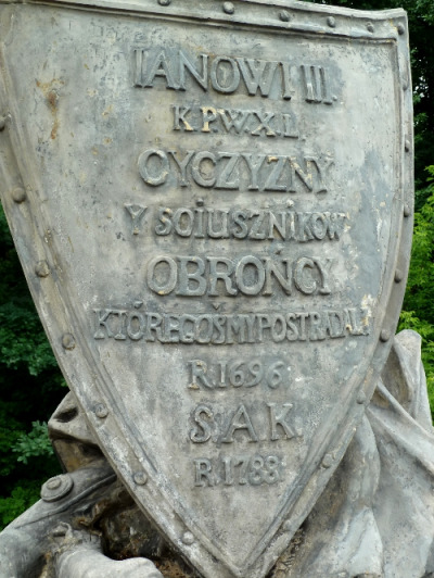 Kolorowe zdjęcie. Przedstawia kadr z pomnika Jana III na Agrykoli i zbliżenie na tarczę i napis po polsku: Janowi III Ojczyzny sojusznikowi. OBrońcy które cośmy postradali. R 1696 SAK R 1788. 