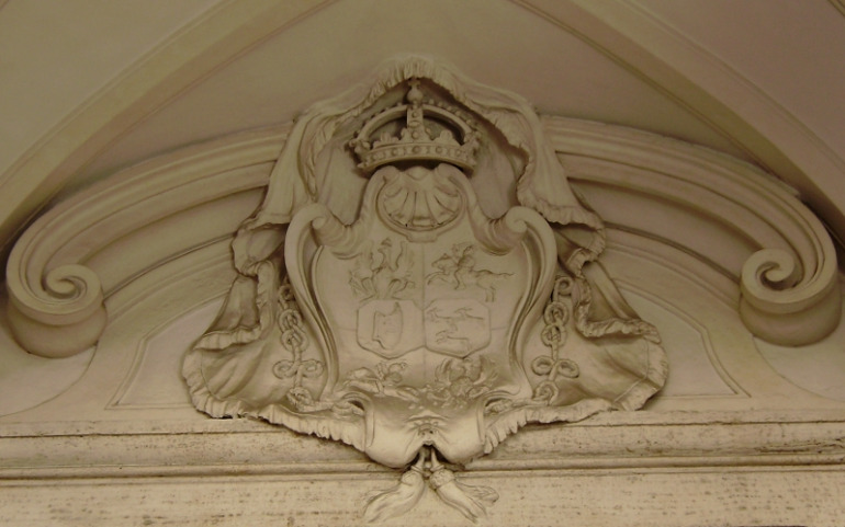 Zdjęcie przedstawia zbliżenie na fragment tzw. architektury małej. Przedstawia fronton nad portalem. Wewnątrz umieszczone są Herby Sobieskich i de la Grange na Palazzo Zuccari. 