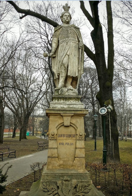 Pomnik Jana III Sobieskiego w Krakowie. Król stoi w lekkim kontrapoście. Ubrany jest w zbroję i długi płaszcz. W prawej ręce trzyma szablę. Rzeźba osadzona na postumencie z piaskowca. Na nim napis: Jan III Sobieski. Król Polski.