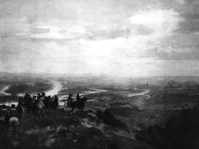 Olej na płótnie. Przedstawia scenę historyczną. Na pagórku stoją jeźdźcy na koniach. Zatrzymali się i patrzą na roztaczające się przed nimi miasto. Połowę obrazu zajmuje niebo z chmurami.