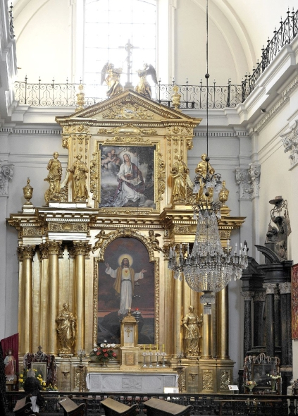 Kolorowe zdjęcie współczesne. Przedstawia wnętrze kościoła i barokowy ołtarz, cały w złocie. W dolnej części obraz Jezusa Chrystusa. Powyżej przedstawienie świętej. Jest to ołtarz św. Felicissimy w kościele św. Krzyża w Warszawie. 