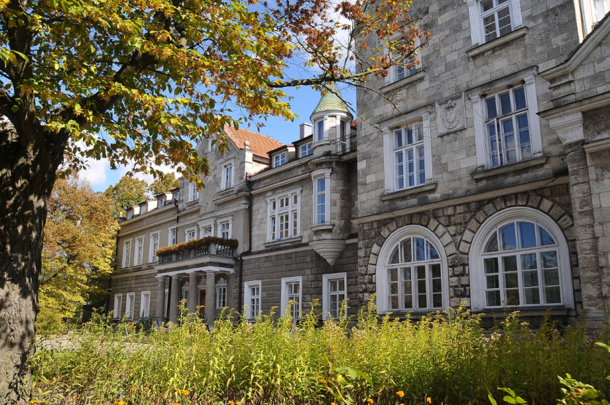 Kolorowe zdjęcie współczesne. Przedstawia budowlę architektoniczną na tle pejzażu. Jest to Pałac Ponińskich w Horyńcu-Zdroju, obecnie sanatorium (widok od południowego-wschodu). 