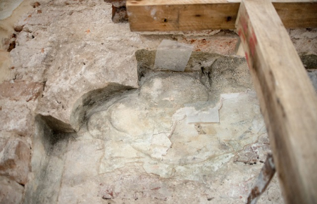 Kolorowe zdjęcie przedstawia odsłonięty fragment płaskorzeźby podczas prac zabezpieczających. 