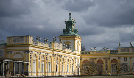 Kolorowe zdjęcie współczesne. Przedstawia skrzydło północne pałacu wilanowskiego. Jest to fasada od strony dziedzińca. 