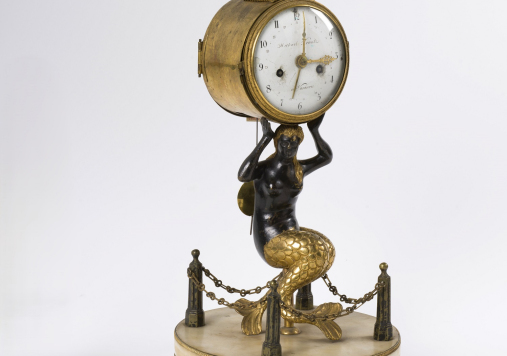 Zegar podtrzymywany przez syrenę ze złotym ogonem.