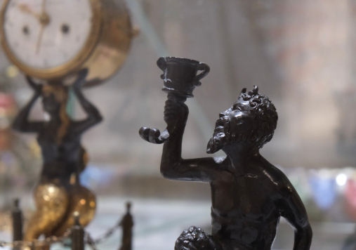 Ciemna figurka fauna z kielichem.