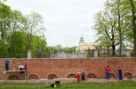 Pracownica muzeum podczas prac konserwatorskich przy murze oporowym